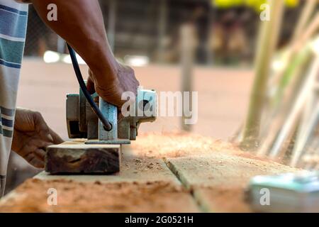 Ein Zimmermann Hand hält ein elektrisches Flugzeug arbeiten auf einem Holzboden, neue Hausbau Ideen und Holzprodukte Industrie. Stockfoto