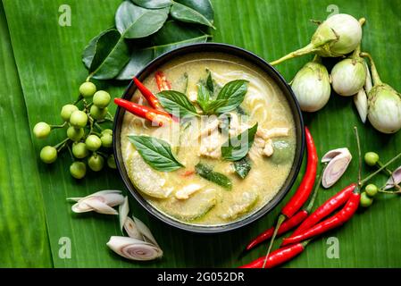 Chicken Green-Chili Thailändisches Essen auf Suppenschüssel mit Zutaten Gemüsekräutern und Gewürzen Pfeffer Chili auf Bananenblatt-Hintergrund, traditionelles grünes Paprika Stockfoto