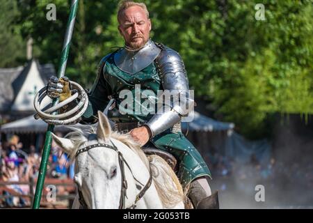 Turnier-Konkurrent des Georgia Renaissance Festival, der während der Spiele in Fairburn (Metro Atlanta), Georgia, ein weißes Pferd reitet. (USA) Stockfoto