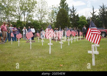 Grove, Usa. Mai 2021. Die Menschen beobachten den Memorial Day Service, bei dem Fahnen und Kreuze in den Boden gepflanzt werden, um Veteranen zu repräsentieren, die in Grove City gestorben sind.die American Legion Paschall Post 164 und Veterans of Foreign war 8198 veranstaltet den Memorial Day Service auf dem Grove City Friedhof. Kredit: SOPA Images Limited/Alamy Live Nachrichten Stockfoto