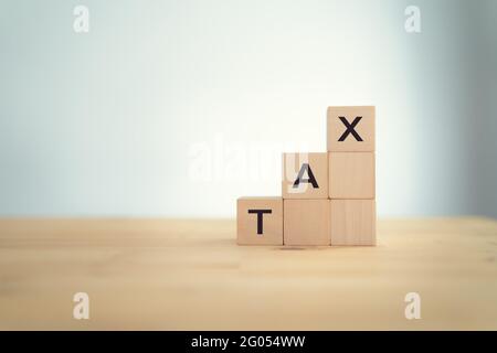 Konzeptwort „Steuer“ auf Holzwürfel auf einem Holztisch. Weißer Hintergrund. Ziel des Geschäfts- und Steuerkonzepts. Steuerplanung und -Verwaltung, Steuerrückerstattung Stockfoto