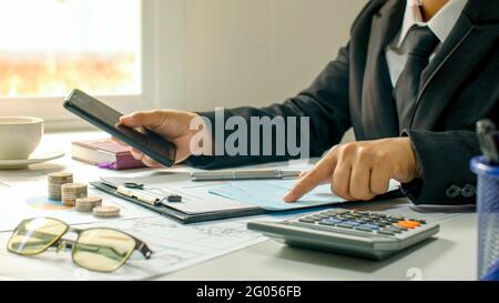 Nahaufnahme eines Geschäftsmannes, eines Mannes, der einen Buchhaltungsbericht überprüft, Ideen zur Kostenberechnung und zum Sparen von Geld. Stockfoto