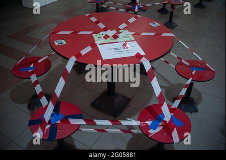 25.05.2021, Singapur, Republik Singapur, Asien - Rot-weißes Warnband wird verwendet, um einen Tisch an einem Essbereich in einem Food Court abzusperren. Stockfoto