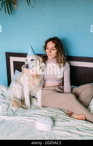 Labrador golden Retriever Hund feiert Geburtstag in Mütze und mit Kuchen. Stockfoto