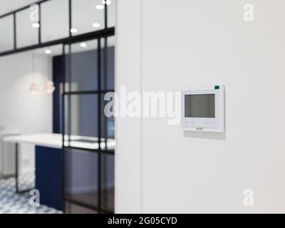 Konsole zur Steuerung von Heizung und Kühlung an der weißen Wand in einer modernen Wohnung. Wandmontiertes Bedienfeld in einem Raum für Klimaanlagen. Stockfoto