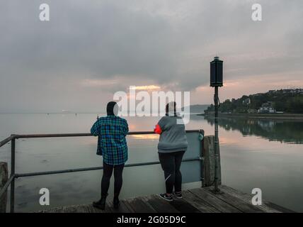 Currabinny, Cork, Irland. Juni 2021. Zwei Frauen waren früh aufgestanden, um die Morgenröte am Currabinny Pier, Co. Cork, Irland, zu beobachten. - Credit; David Creedon / Alamy Live News Stockfoto