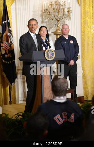 Berichtet: Präsident Barack Obama spricht bei einer Veranstaltung im Weißen Haus zu Ehren der US-Athleten der Olympischen und Paralympischen Winterspiele 2014 in Washington, D.C., 3. April 2014. Mit Obama abgebildet sind Julie Chu von Fairfield, Conn, die mit der olympischen Eishockeymannschaft der Frauen Silber gewann; und (ganz rechts) Jon Lujan von Littleton, Colorado, Paralympics Alpine Skiing, ehemaliger Marine Corps Sergeant und Eröffnungszeremonie der Olympischen Winterspiele 2014 bei den Olympischen Winterspielen in den USA. Stockfoto