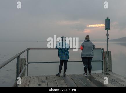 Currabinny, Cork, Irland. Juni 2021. Zwei Frauen waren früh aufgestanden, um die Morgenröte am Currabinny Pier, Co. Cork, Irland, zu beobachten. - Credit; David Creedon / Alamy Live News Stockfoto