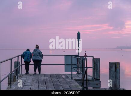 Currabinny, Cork, Irland. Juni 2021. Zwei Frauen waren früh aufgestanden, um die Morgenröte am Currabinny Pier, Co. Cork, Irland, zu beobachten. - Credit; David Creedon / Alamy Live News Stockfoto