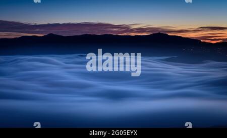 Creu de Sant Miquel Vewpoint, in Montserrat, in der Nacht, mit einem Meer von Wolken - Nebel (Barcelona, Katalonien, Spanien) Stockfoto