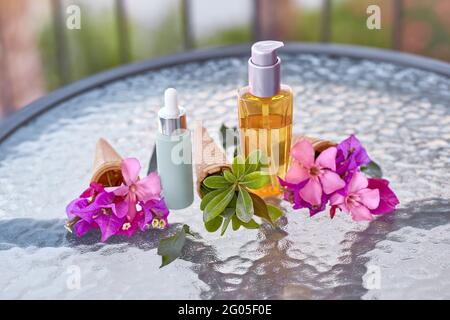 Surreal leuchtend rosa Bougainvillea blüht in einem Eiskegel und imitierte Kosmetikflaschen. Kosmetische Ölflasche und Tröpfchenglasflasche. Sommer Beauty-Produkte Hintergrund Stockfoto