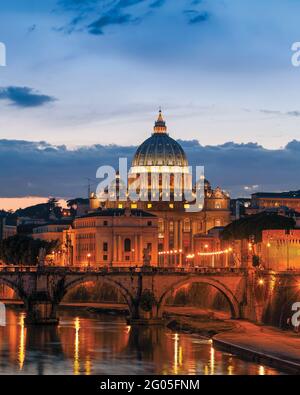 Rom, Italien. Die Brücke Sant'Angelo und der Petersdom in der Abenddämmerung. Das historische Zentrum von Rom ist ein UNESCO-Weltkulturerbe. Stockfoto