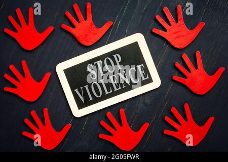 Stop Gewalt Zeichen und rote Hände auf der dunklen Oberfläche. Stockfoto