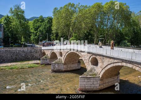 Stromaufwärts ist die Latin Bridge eine osmanische Brücke über den Fluss Miljacka, Sarajevo, Bosnien und Herzegowina Stockfoto