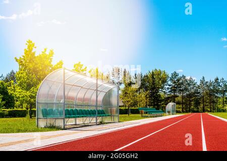 Perspektivische Ansicht eines Freiluftstadions mit roten Laufstrecken, Plastikstühlen, Infrastruktur für sportliche Aktivitäten Stockfoto