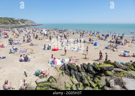 Massen am sonnigen Sandstrand von Folkestone am Montag an den Frühlingsferien im Mai Stockfoto