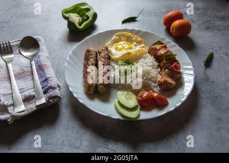 Mittelöstliches Gericht chelo Kebab aus Lammkebabs, die gegrillt werden und mit gegrillten Tomaten und Basmati oder Aromareis serviert werden. Nahaufnahme. Stockfoto