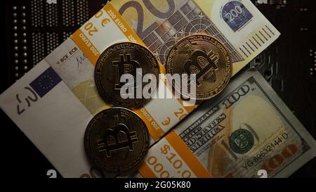 Bitcoin-Nahaufnahme von 100-Dollar-Scheinen und 200-Euro-Banknoten, Weißlicht-Draufsicht, Finanz- und Krypto-Konzept Stockfoto