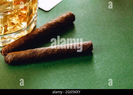 Nahaufnahme von Whiskey-Glas und Zigarre auf grünem Hintergrund Stockfoto