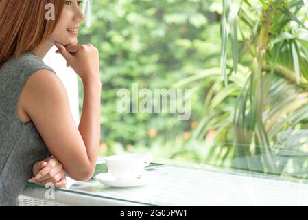 Arbeiten schöne Frau sitzt auf schwarz-weißem Sofa mit Technologie mit Smart Tablet modernen Lebensstil. Suche im Internet und Online-Shopping. Stockfoto