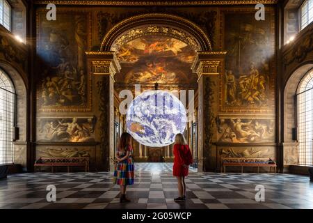 London, Großbritannien, 1. Juni 2021. Mitarbeiter sehen die „Gaia“ des Künstlers Luke Jerram, die in der Painted Hall des Old Royal Naval College in Greenwich installiert wurde. Die maßstabsgetreue Nachbildung der Erde dreht sich langsam, um ein Gefühl für den Overview-Effekt zu vermitteln, den Astronauten erleben, wenn sie die Erde aus dem All sehen. Das Werk ist bis zum 1. Juli zu sehen. Kredit: Stephen Chung / Alamy Live Nachrichten Stockfoto