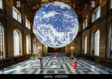 London, Großbritannien, 1. Juni 2021. Mitarbeiter sehen die „Gaia“ des Künstlers Luke Jerram, die in der Painted Hall des Old Royal Naval College in Greenwich installiert wurde. Die maßstabsgetreue Nachbildung der Erde dreht sich langsam, um ein Gefühl für den Overview-Effekt zu vermitteln, den Astronauten erleben, wenn sie die Erde aus dem All sehen. Das Werk ist bis zum 1. Juli zu sehen. Kredit: Stephen Chung / Alamy Live Nachrichten Stockfoto