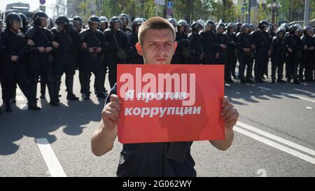 MOSKAU, RUSSLAND - am 5. MAI 2018 steht EIN junger Mann auf der Protestkundgebung gegen Präsident Wladimir Putin mit einem roten Plakat "Ich bin gegen Korruption". Stockfoto