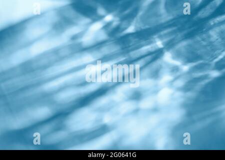 Overlay-Effekt mit Wassertextur für Fotos und Mockups. Organischer, diagonaler Schatten und leichte ätzende Wirkung auf eine blaue Wand Stockfoto