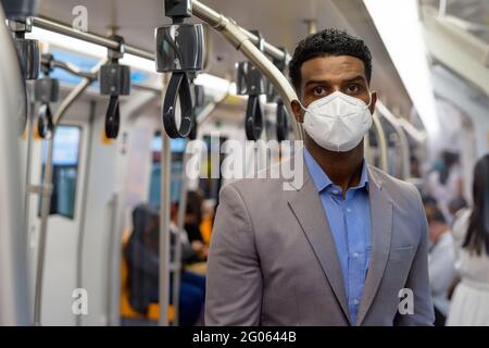 Afrikanischer Geschäftsmann im Zug trägt Gesichtsmaske Stockfoto