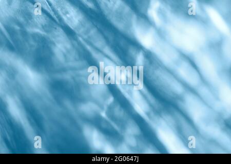 Overlay-Effekt mit Wassertextur für Fotos und Mockups. Organischer, diagonaler Schatten und leichte ätzende Wirkung auf eine blaue Wand Stockfoto