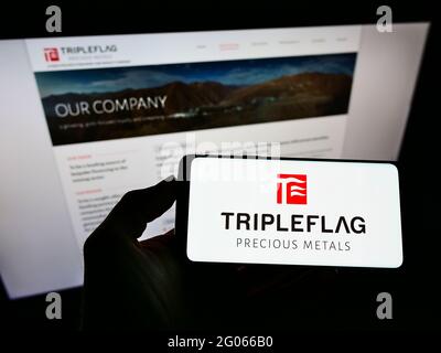 Person, die ein Smartphone mit dem Logo des kanadischen Unternehmens Triple Flag Precious Metals Corp. Auf dem Bildschirm vor der Website hält. Konzentrieren Sie sich auf die Telefonanzeige. Stockfoto