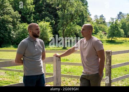 Zwei Jungs, die eine ernsthafte Diskussion auf einer Ranch führen Stockfoto