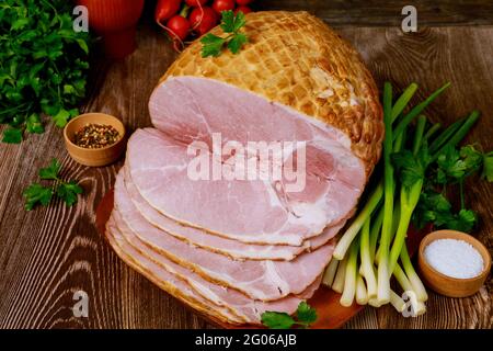 Köstlicher gekochter Schinken auf einem Holzbrett mit grünen Zwiebeln, Salz und Rettich. Stockfoto