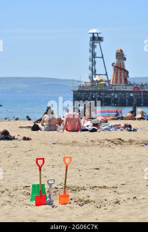 Menschen am Strand am heißesten Tag des Jahres, dem ersten Tag des meteorologischen Sommers. Frühsommer Heatwave, Bournemouth, Dorset, England UK, 1. Juni 2021, UK. Heißes Wetter. Stockfoto