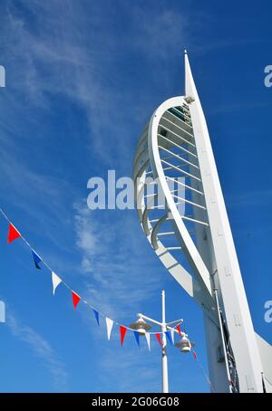 Blick auf den Spinnaker Tower in Portsmouth mit roten und weißen Fahnen im Vordergrund. Stockfoto