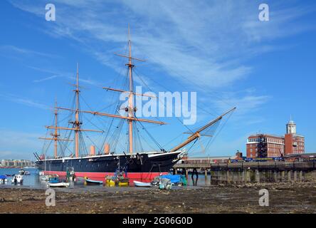 HMS Warrior bei Ebbe vor dem historischen Hafengelände von Portsmouth. Am frühen Morgen Weitwinkelansicht. Stockfoto