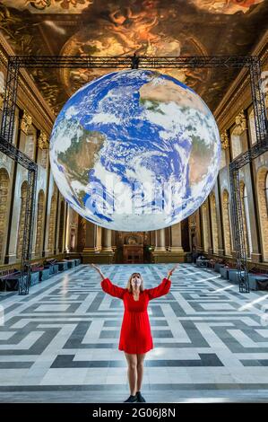 London, Großbritannien. Juni 2021. Gaia kehrt diesen Sommer zum Old Royal Naval College in Greenwich zurück. Sie wird einen Monat lang in der Painted Hall ausgestellt. Die Skulptur von Luke Jerram dreht sich langsam, während sie in der Luft schwebt, eine maßstabsgetreue Nachbildung der Erde, die mit NASA-Bildern angefertigt wurde. Innen beleuchtet ist er 1.8 Millionen mal kleiner als die Erde. Kredit: Guy Bell/Alamy Live Nachrichten Stockfoto