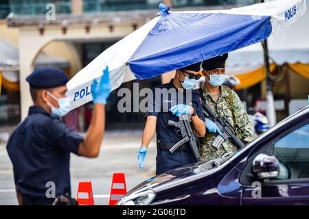 Kuala Lumpur, Malaysia. Juni 2021. Polizisten und ein Soldat überprüfen Fahrzeuge an einer Straßensperre in Kuala Lumpur, Malaysia, 1. Juni 2021. Malaysia begann am Dienstag landesweit eine zweiwöchige Sperre, um die COVID-19-Infektionen zu reduzieren. Es dürfen nur wichtige Sektoren arbeiten und es gibt Reisebeschränkungen, um die Menschen in einem Umkreis von 10 km von ihrem Zuhause zu halten. Quelle: Zhu Wei/Xinhua/Alamy Live News Stockfoto