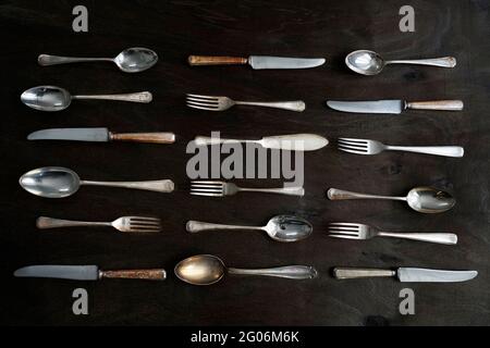 Set aus Vintage englischem Silberbesteck auf dunklem Holzhintergrund, Draufsicht Stockfoto