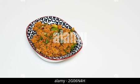 Kisir in einer kleinen Schüssel, traditionelle leckere türkische Speisen: Bulgur-Salat, isoliert von einem weißen Hintergrund mit Platz für Text Stockfoto