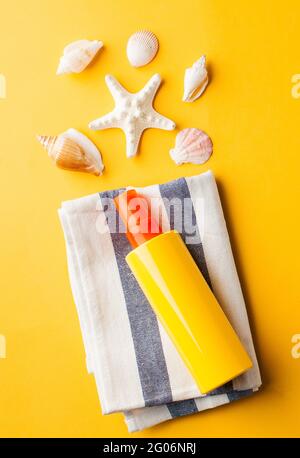 Summer background. Seashells, sunscreen on a yellow background.  Stockfoto