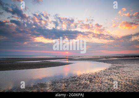 Ein farbenfroher Sonnenuntergang vom Ufer in Barassie bei Troon in South Ayrshire, Schottland. Stockfoto