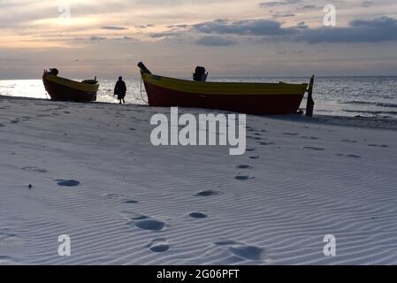 woan beim Spaziergang am sady Strand zwischen zwei traditionellen Fischerbooten an der Ostsee Stockfoto