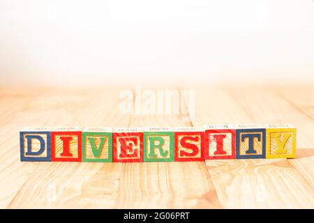 Spektakuläre Holzwürfel mit dem Wort VIELFALT auf einer Holzoberfläche. Stockfoto