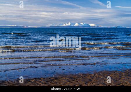 Ein Blick über den Firth of Clyde zu den schneebedeckten Bergen auf der Isle of Arran vom Ufer bei Barassie in South Ayrshire, Schottland. Stockfoto
