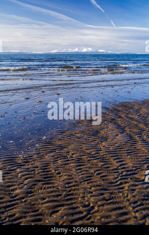 Ein Blick über den Firth of Clyde zu den schneebedeckten Bergen auf der Isle of Arran vom Ufer bei Barassie in South Ayrshire, Schottland. Stockfoto
