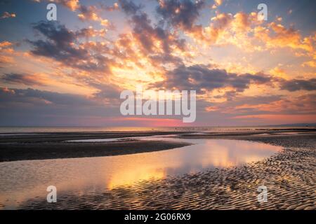 Ein farbenfroher Sonnenuntergang vom Ufer in Barassie bei Troon in South Ayrshire, Schottland. Stockfoto