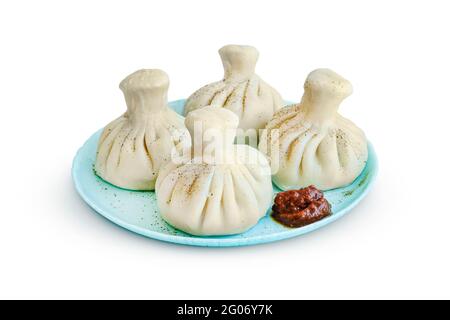 Khinkali auf einer Untertasse mit scharfer Adjika isoliert auf weißem Hintergrund Stockfoto