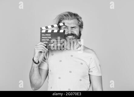 Film ansehen. Filmregisseur. Schauspieler beim Casting. Aufnahmeszene. Lieblingsserie. Aktion. Kinoproduktion. Kreativer Produzent. Bärtiger Mann hält Film Stockfoto