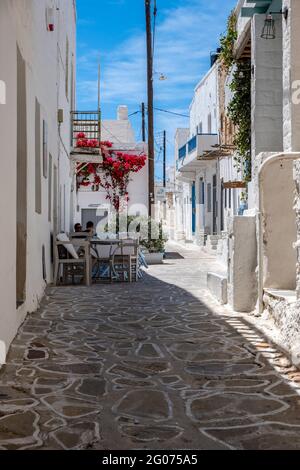 Griechenland, Kimolos-Insel. Kykladen. 18.Mai 2021. Zwei Männer in einem Café im Dorf Chora. Griechische traditionelle Architektur weiß getünchte Gebäude und enge cobb Stockfoto